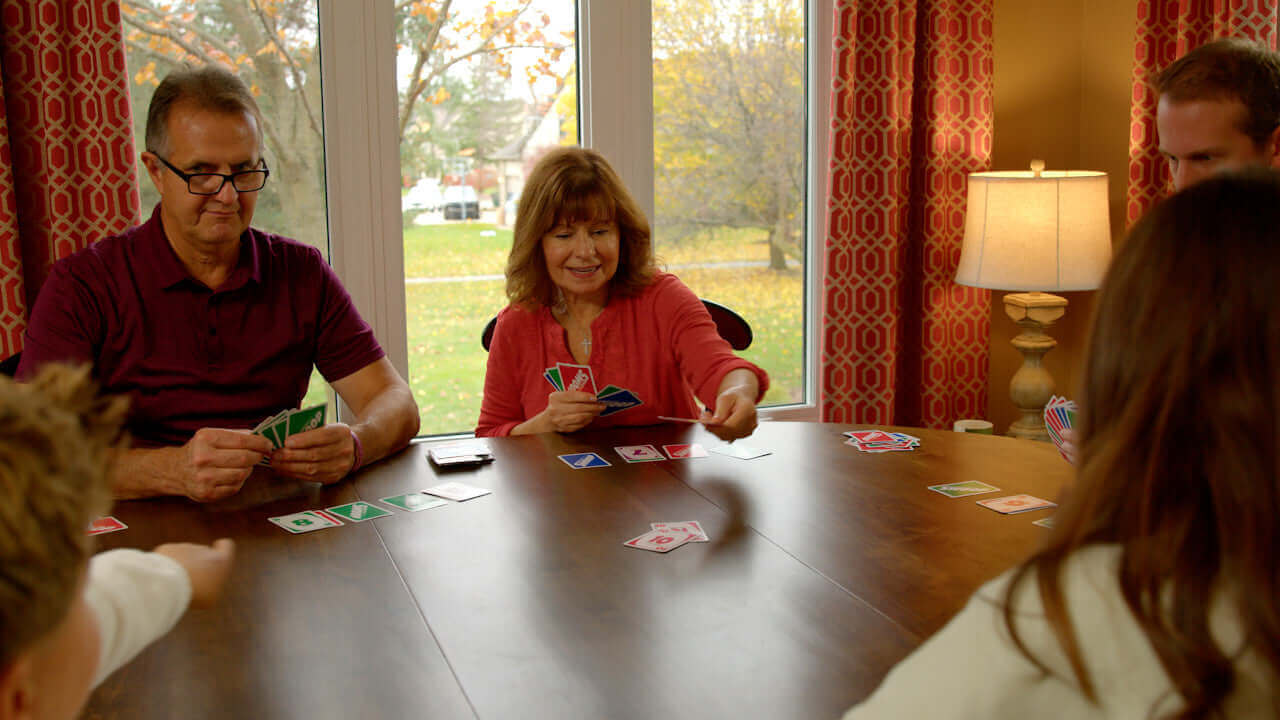 Grandpa keeping his eye on Grandson who is ready to play his last card.
